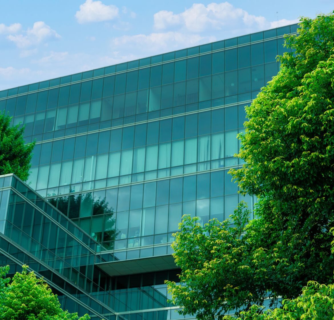 Energy-efficient glass facade with Low-E insulating glass units surrounded by green trees